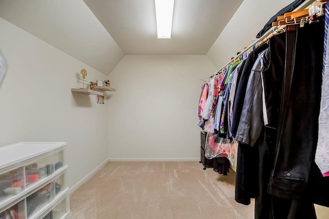 spacious closet featuring vaulted ceiling and light carpet