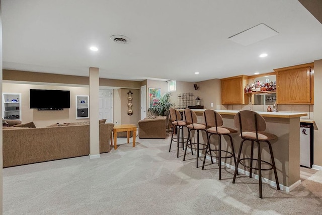 kitchen with a breakfast bar and light carpet