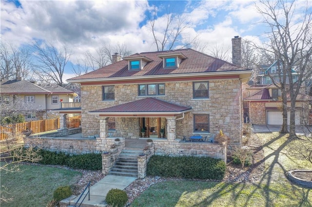 american foursquare style home featuring a chimney, fence, and a porch