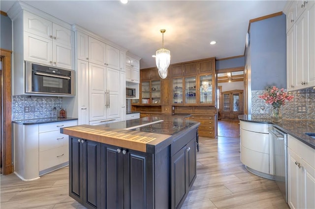 kitchen featuring white cabinetry, a kitchen island, wooden counters, and decorative light fixtures