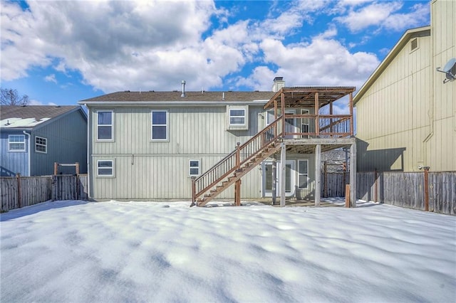 snow covered rear of property featuring a wooden deck