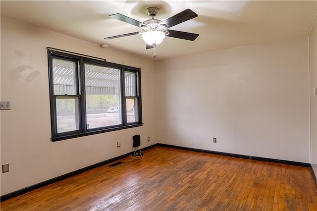 spare room featuring baseboards, ceiling fan, hardwood / wood-style floors, and visible vents