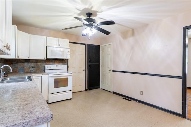 kitchen featuring white appliances, white cabinets, a sink, and light countertops