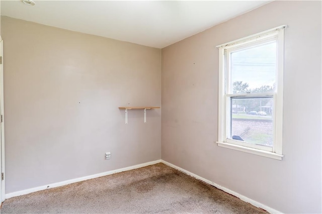 spare room featuring baseboards and carpet