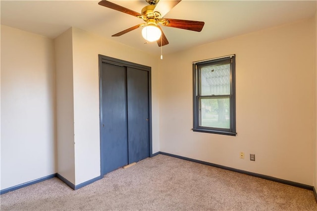 unfurnished bedroom featuring a ceiling fan, baseboards, light carpet, and a closet