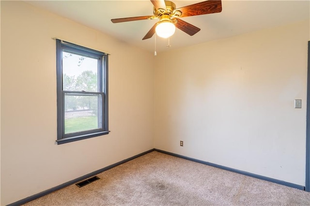 unfurnished room featuring baseboards, visible vents, ceiling fan, and carpet
