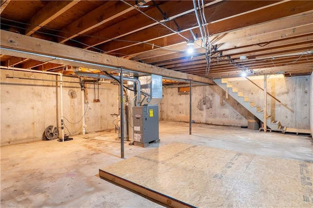 unfinished basement featuring heating unit and stairs