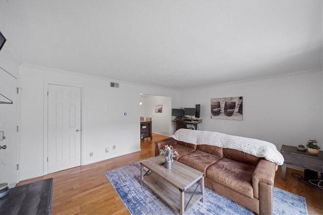 living room with wood-type flooring and ornamental molding