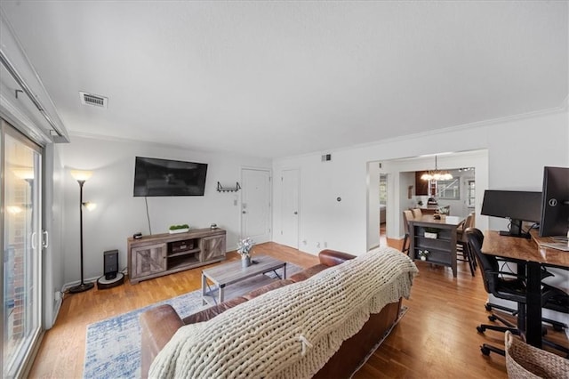 bedroom featuring an inviting chandelier, ornamental molding, and wood-type flooring