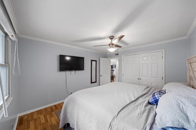 bedroom featuring ceiling fan, a closet, ornamental molding, and hardwood / wood-style floors