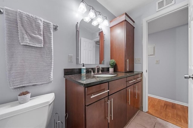 bathroom with toilet, tile patterned flooring, and vanity