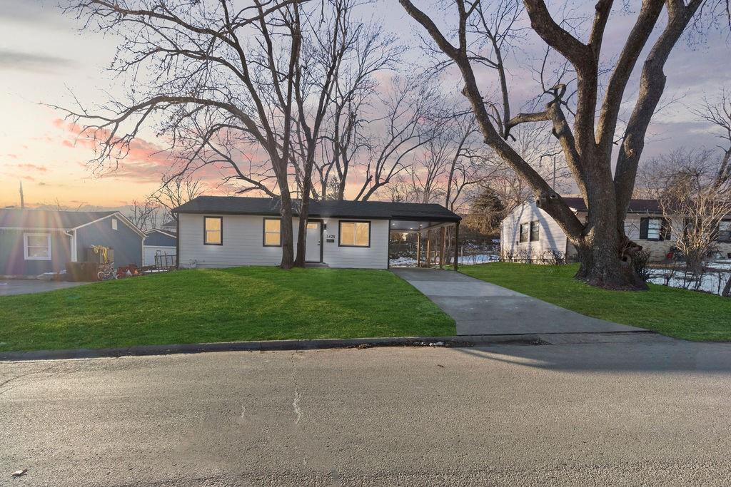 view of front of house with a carport and a lawn