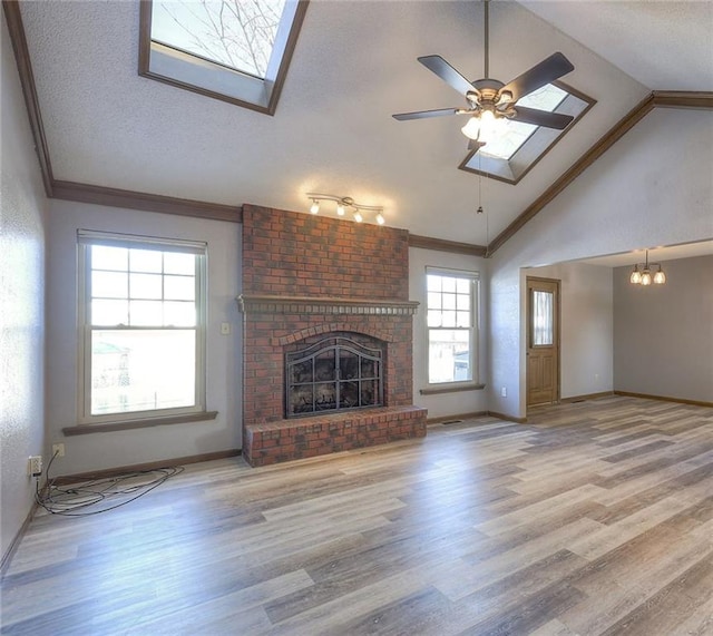 unfurnished living room featuring lofted ceiling, a fireplace, hardwood / wood-style floors, a textured ceiling, and ceiling fan with notable chandelier