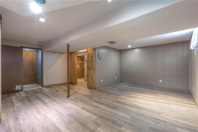 basement featuring wood-type flooring and wooden walls