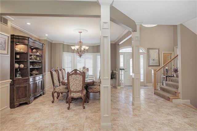 dining area featuring a chandelier, decorative columns, and crown molding