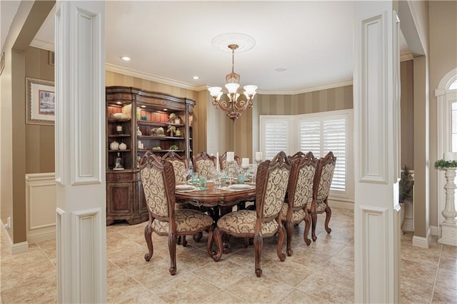 dining space with ornamental molding, a chandelier, and ornate columns