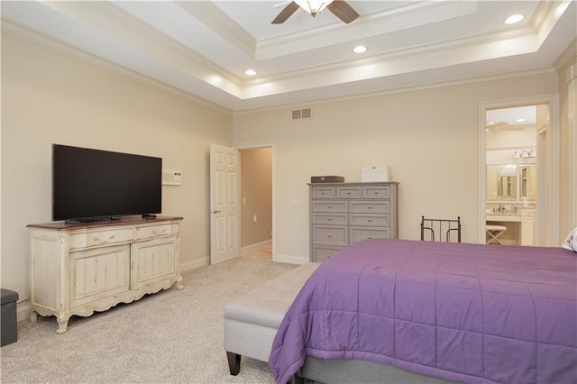 carpeted bedroom featuring ensuite bath, ceiling fan, a tray ceiling, and ornamental molding