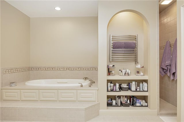 bathroom featuring separate shower and tub, radiator, and tile patterned floors