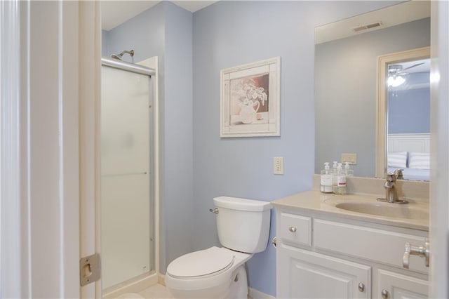 bathroom with toilet, vanity, and a shower with shower door