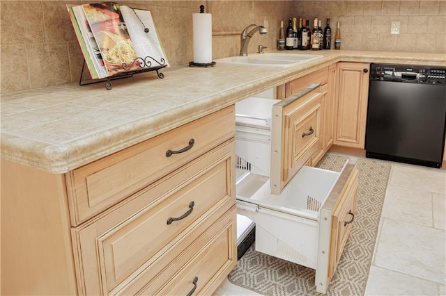 kitchen featuring tile countertops, sink, backsplash, black dishwasher, and light brown cabinets