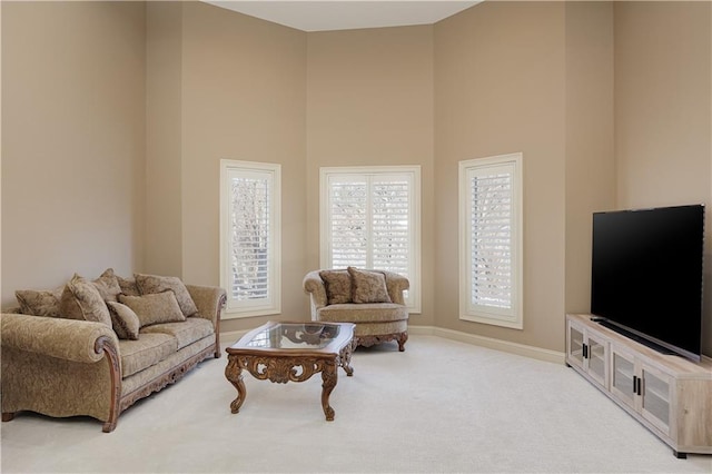 carpeted living room featuring a towering ceiling