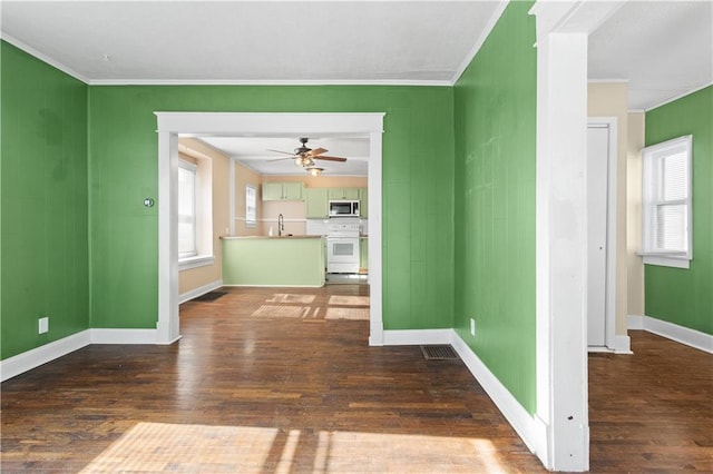 interior space featuring ceiling fan, ornamental molding, and dark hardwood / wood-style floors