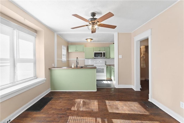 kitchen featuring white appliances, backsplash, plenty of natural light, and green cabinets