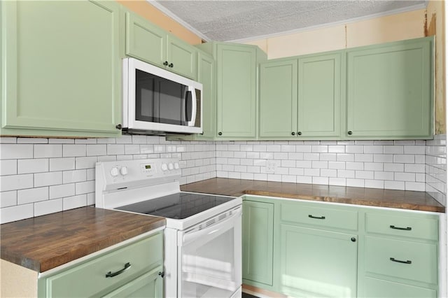 kitchen featuring white appliances, wooden counters, a textured ceiling, and tasteful backsplash