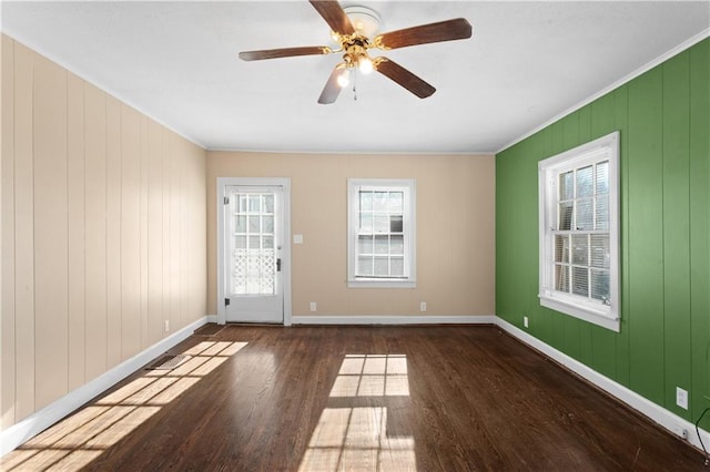 spare room featuring ceiling fan, dark hardwood / wood-style floors, crown molding, and plenty of natural light