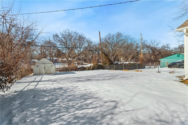 yard layered in snow featuring a storage unit