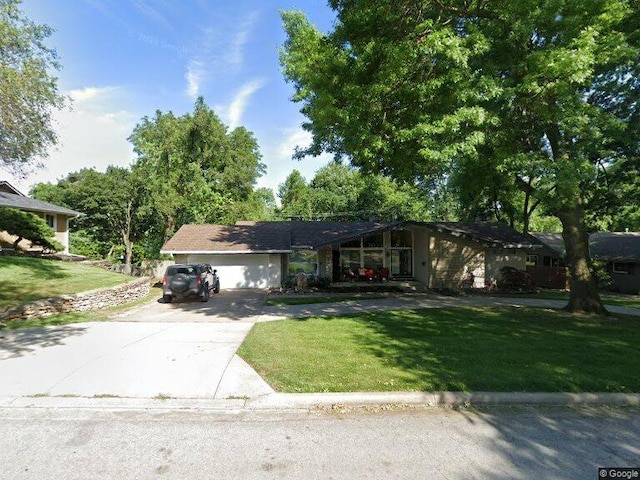 ranch-style home with a garage and a front lawn