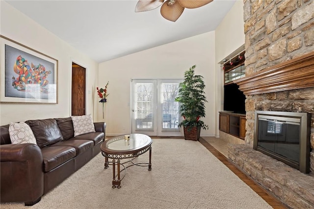 living room featuring hardwood / wood-style flooring, vaulted ceiling, ceiling fan, and a fireplace