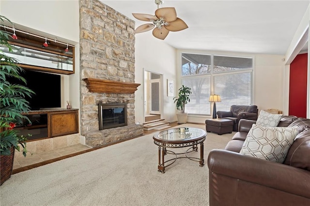 carpeted living room with a fireplace, ceiling fan, and vaulted ceiling