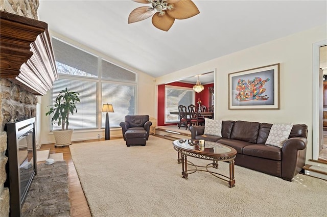 living room featuring hardwood / wood-style flooring, ceiling fan, lofted ceiling, and a fireplace