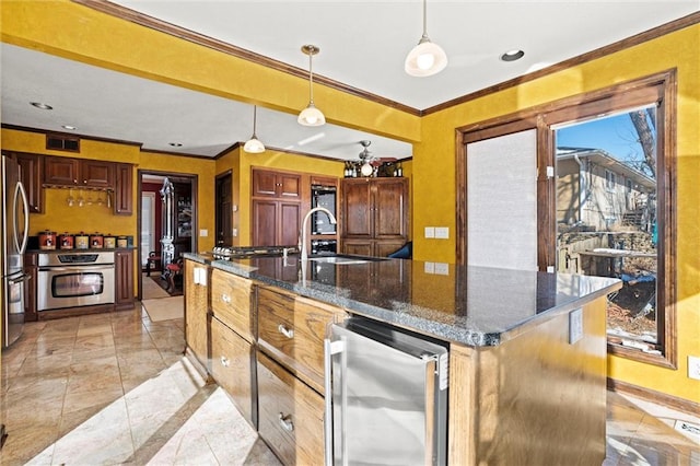 kitchen with decorative light fixtures, ornamental molding, appliances with stainless steel finishes, an island with sink, and beverage cooler