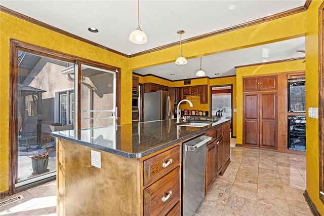 kitchen featuring sink, decorative light fixtures, ornamental molding, stainless steel appliances, and a kitchen island with sink