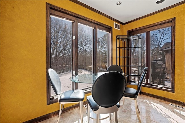 dining space featuring crown molding