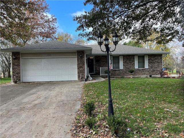 single story home with a garage and a front lawn