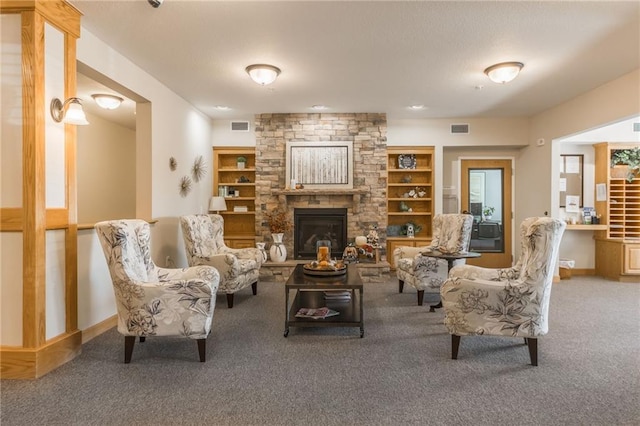 living room featuring a fireplace, carpet floors, and built in shelves