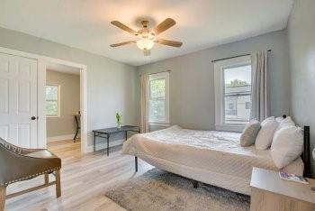 bedroom with light wood-type flooring, ceiling fan, and multiple windows