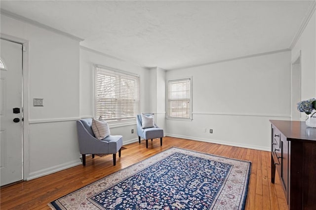 sitting room with hardwood / wood-style flooring and ornamental molding