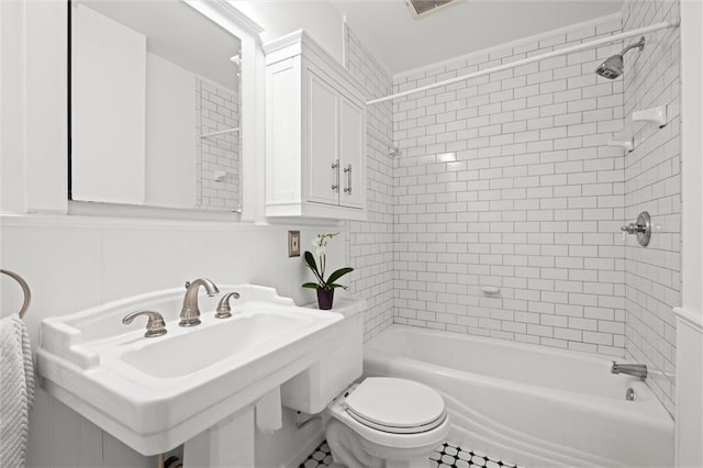 full bathroom featuring tiled shower / bath combo, sink, and toilet