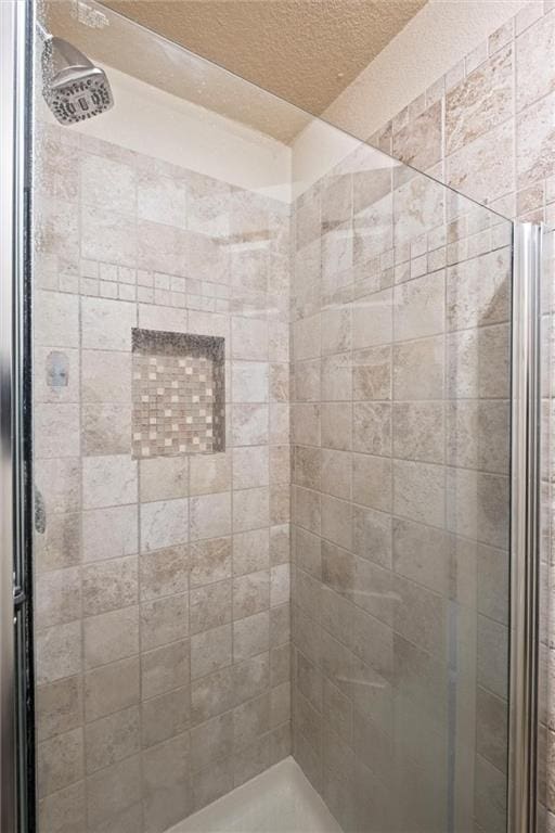 bathroom with an enclosed shower and a textured ceiling