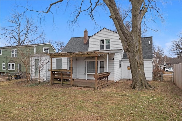 rear view of property with a yard, a pergola, and a deck