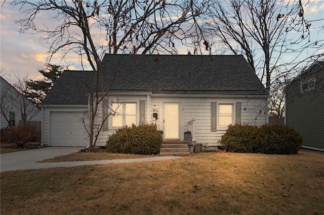 view of front of property featuring a garage and a yard