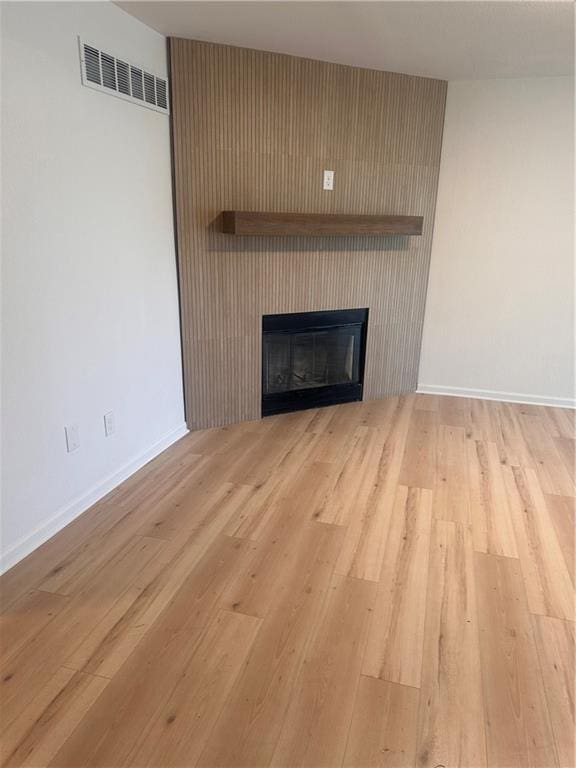 room details featuring a large fireplace and wood-type flooring