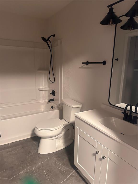 full bathroom featuring bathing tub / shower combination, vanity, and toilet