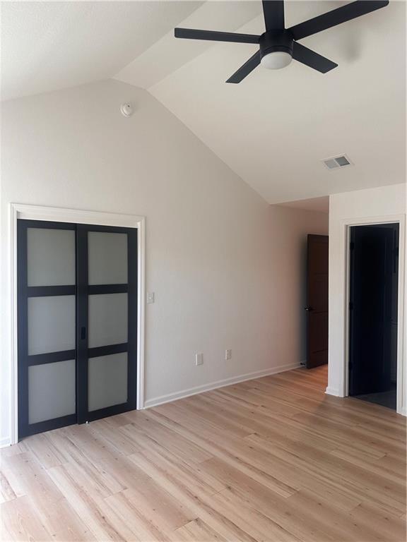 spare room featuring vaulted ceiling, light wood-type flooring, and ceiling fan