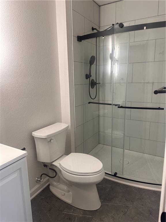 bathroom featuring toilet, walk in shower, and vanity