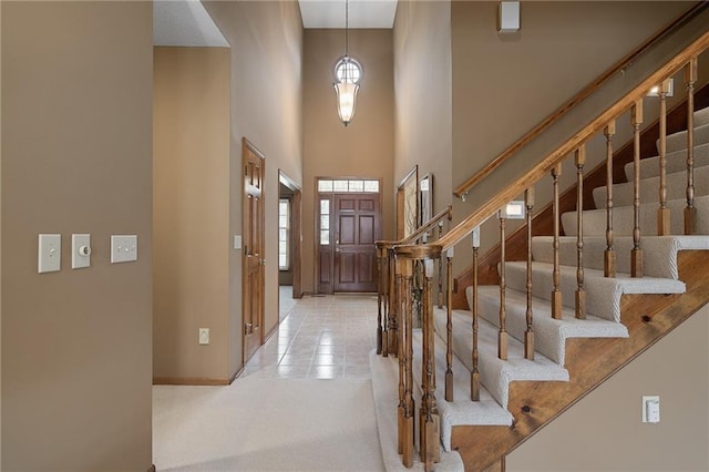 foyer featuring a towering ceiling and light tile patterned flooring